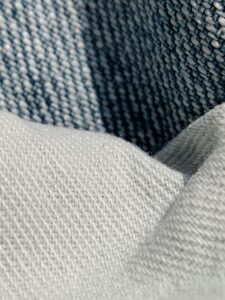 Clothing label showing 100% cotton fabric composition for sustainable fashion.