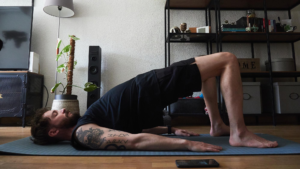 Man practicing low-impact Pilates on a yoga mat, illustrating a cortisol-friendly workout routine to lower stress hormones compared to high-intensity HIIT.