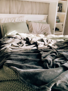 Cozy bed setting representing a slow morning routine for productive days and mental wellness.