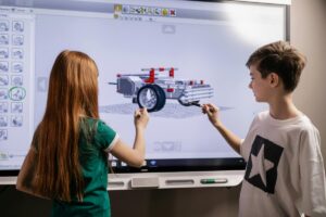 : "Students using interactive AI whiteboard for 3D modeling project.”
