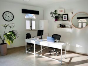 A bright, minimalist modern office workspace with a white desk and greenery, representing a streamlined AI-first productivity environment for 2026.”