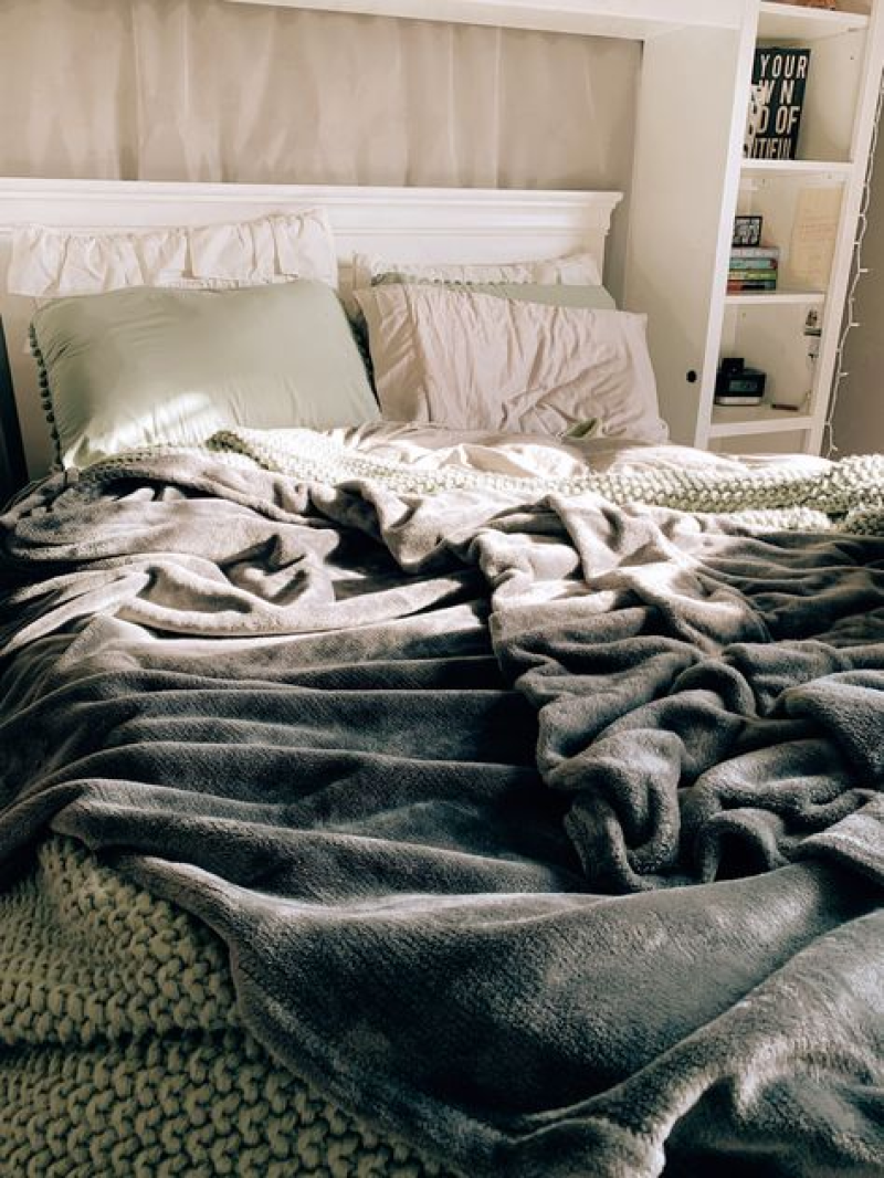 Cozy bed setting representing a slow morning routine for productive days and mental wellness.